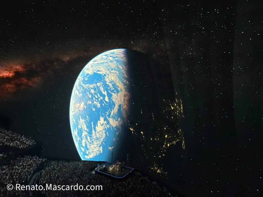 A view of Earth from space, illuminated with city lights at night, against a backdrop of a starry sky and cosmic elements.